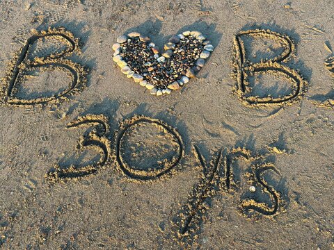 A heartwarming anniversary message 'B Heart B 30 yrs' written in the sand at the scenic Moonstone Beach in Cambria, California.
