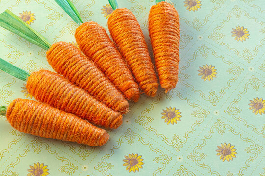 Yarn Woven Orange Carrots on a Green Floral Background