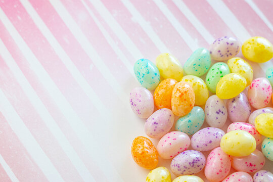 Colorful Speckled Jelly Beans on a Pink Striped Background