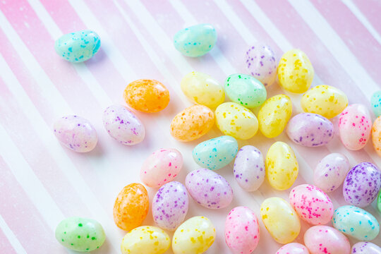 Colorful Speckled Jelly Beans on a Pink Striped Background