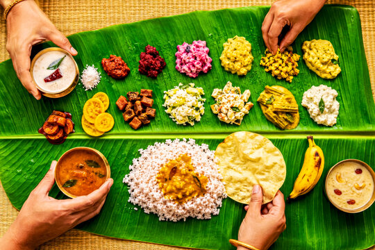 Overhead View of Traditional Onam Meal Served on Banana Leaf with Hands Sharing Kerala Festival Food