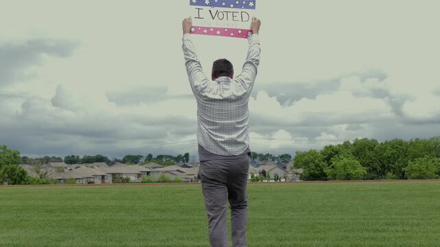 Man holding a humorous, satirical campaign sign reading I Voted for a nap, capturing themes of election fatigue, voting fatigue, and political burnout