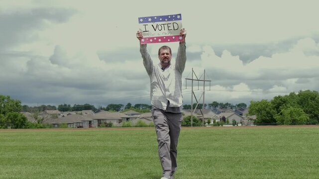 Man holding a humorous, satirical campaign sign reading I Voted for a nap, capturing themes of election fatigue, voting fatigue, and political burnout