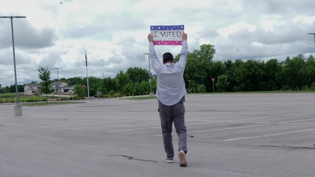 Man holding a humorous, satirical campaign sign reading I Voted for a nap, capturing themes of election fatigue, voting fatigue, and political burnout