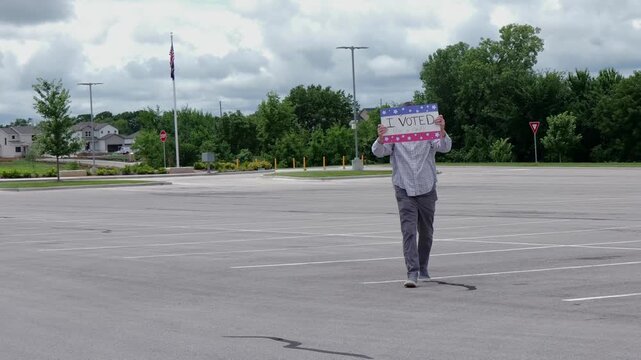 Man holding a humorous, satirical campaign sign reading I Voted for a nap, capturing themes of election fatigue, voting fatigue, and political burnout