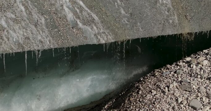 Ngozumpa Glacier Everest, Nepal, Lateral drone shot of water dripping rapidly from a melting glacial ice wall due to climate change and global warming in the Himalayas.