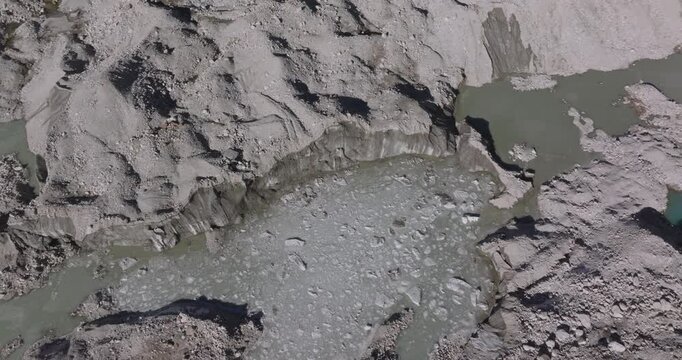 Ngozumpa Glacier Everest Nepal, top-down view of melting glacial ice forming supraglacial ponds across rugged debris-covered terrain due to global warming.
