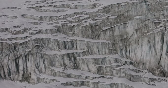 Cho Oyu mountain, Everest region, Nepal, aerial sideways gliding shot of unique glacial ice formation structures and crevasses across a high altitude Himalayan glacier.