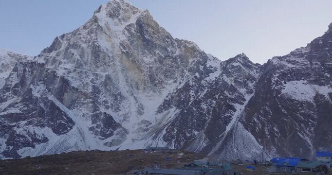 Zongla village Everest region Nepal, aerial drone shot of high-altitude settlement nestled at the base of the steep, snow-covered rock face of Cholatse peak along the Three Passes Trek