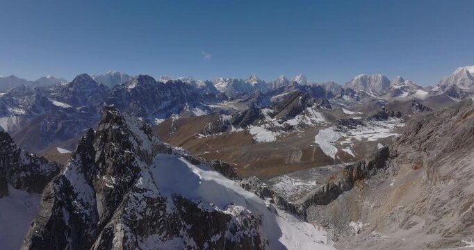 Chola Pass Everest region Nepal, drone view of rugged rocky mountain peaks with patches of snow and vast high-altitude alpine valleys under a clear blue sky