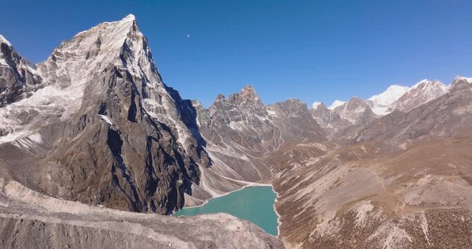 Chola Tshe Lake Nepal, drone shot over a turquoise glacial lake nestled beneath the rugged walls of Cholatse peak in the Everest region.