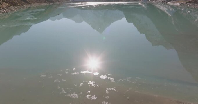 Chola Tshe Lake Nepal, aerial gliding shot over calm turquoise waters revealing a perfect reflection of Ama Dablam mountain in the Everest region.
