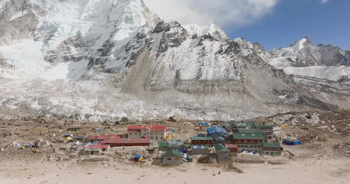 Gorakshep, Everest Region Nepal, aerial pull out shot from the remote high altitude hamlet to reveal the massive scale of the surrounding Khumbu Glacier and towering Himalayan peaks.