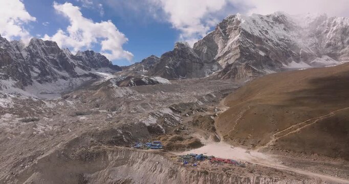 Gorakshep, Everest Region Nepal, drone slowly orbits the rocky Khumbu Glacier moraine and alpine hills along the Everest Base Camp trekking route beneath a clear blue sky.