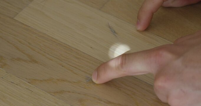 Close-up of scratches and surface damage on a hardwood parquet floor. Concept of home maintenance, wear and tear, flooring repair, property damage, and interior renovation.