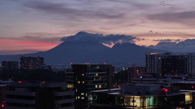 Vista de altura de Ciudad de Guatemala con rascacielos residenciales y luces urbanas de noche. Atardecer dram&aacute;tico y colorido sobre el horizonte de la Ciudad de Guatemala.