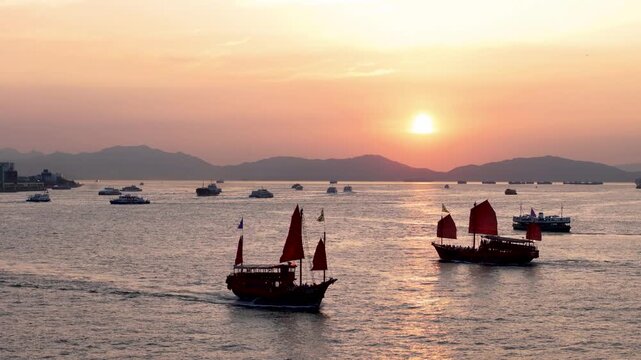 Two Aqua Luna crossing paths with sunset in background, Hong Kong