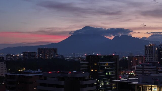 Vista de altura de Ciudad de Guatemala con rascacielos residenciales y luces urbanas de noche. Atardecer dram&aacute;tico y colorido sobre el horizonte de la Ciudad de Guatemala.