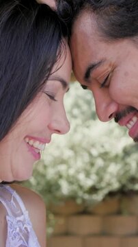 Vertical video: Pressing brows couple showing love in pergola pink drape lace dress black tie