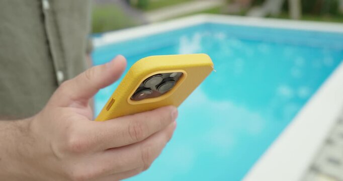 using a smartphone by the pool during a sunny vacation. Focus on mobile browsing, travel lifestyle, and the concept of roaming charges while abroad.
