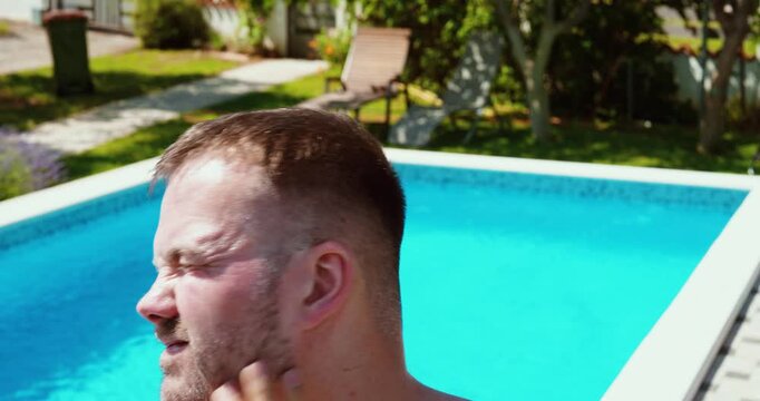 Close-up of a person applying sunscreen to their face beside a swimming pool. Focus on sun protection, skincare routine, and summer outdoor lifestyle.