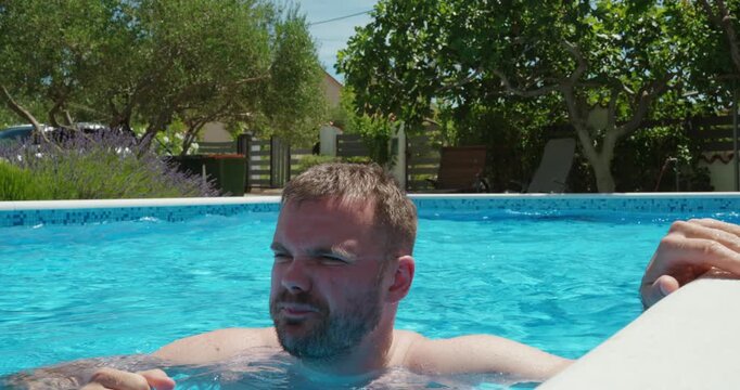 Man spitting and clearing his nose while inside a swimming pool. Pool hygiene, public health awareness, inappropriate behavior, and swimming facility rules concept.