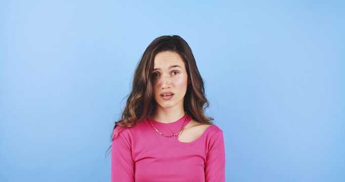 Young woman looking away with confused facial expression, shrugging shoulders with doubt and uncertainty portrait isolated on blue background, concept of being lost, lack of information and hesitation