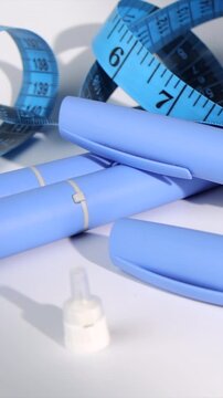 Vertical side camera slide layout of blue semaglutide medication pens for chronic obesity treatment and health care on white base