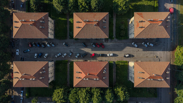 Aerial view of residential buildings with terracotta roofs and parked cars on the street in Turin, Piedmont, Italy.