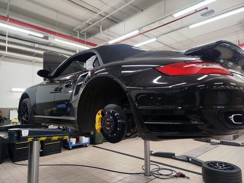 Moscow, Russia - June 26, 2026: A Porsche 911 sports car (model 997 Turbo Cabrio) is on a lift at a car service center. It is undergoing repairs and maintenance. 