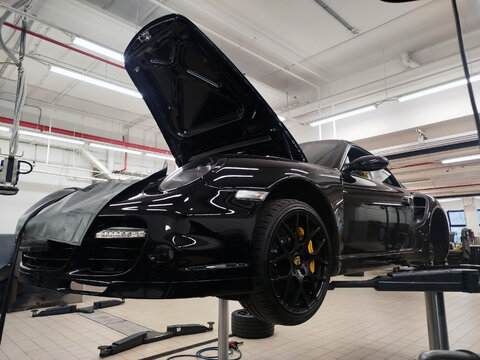 Moscow, Russia - June 26, 2026: A Porsche 911 sports car (model 997 Turbo Cabrio) is on a lift at a car service center. It is undergoing repairs and maintenance. 