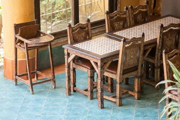 Fotobehang Horeca Traditional Moroccan Restaurant Interior with Handcrafted Wooden Furniture and Baby High Chair.  Authentic interior of a traditional Moroccan restaurant featuring handcrafted wooden tables  © NataSao
