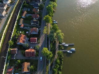 Naklejka premium Aerial View of Lakeside Residential Area with Houses, Road and Boat Docks