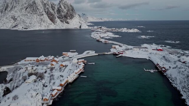 Aerial winter view of a snowy coastal village and harbor by the sea