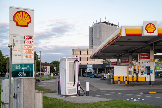 Wolfsburg, Germany, 21 May 2026: Shell petrol station in Germany featuring traditional fuel price display columns and Recharge electric vehicle charging terminals under a cloudy sky
