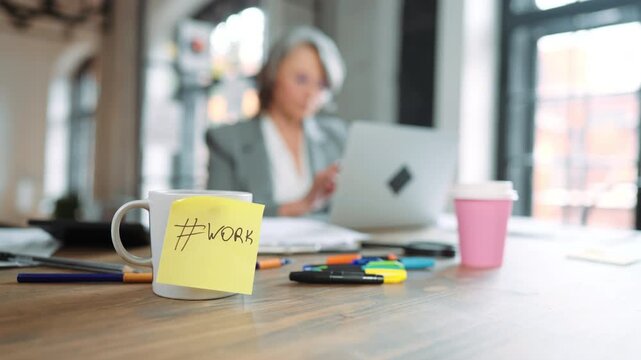 Career and job, lady in office, sticky note with hashtag work inscription on cup . Senior woman boss using laptop in co-working area in modern office building, work-life balance of contemporary women