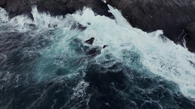 Aerial view of waves crashing against rocky coastline