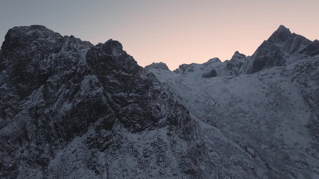 Snow covered alpine mountain ridge at dawn