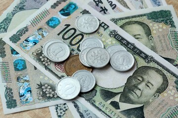 Japanese yen money bills and coins on table. Japan cash of JPY currency close up © Larysa