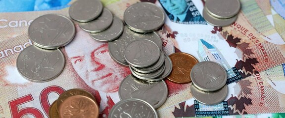 Obraz premium Canadian dollar money bills and coins on table. Canada cash of CAD currency close up
