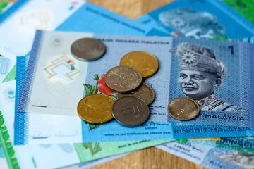 Malaysian ringgit money bills and coins on table. Malaysia cash of MYR currency close up © Larysa