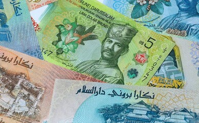 Brunei dollar money banknotes bunch on table. Brunei bills of BND currency close up © Larysa