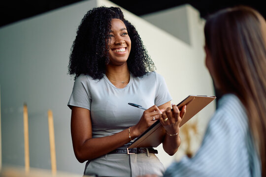 Happy black entrepreneur on business meeting with her coworkers in office.
