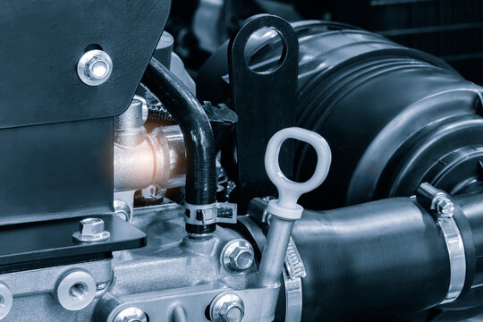 Cose-up car engine with oil level gauge in crankcase in  foreground. Auto repair and maintenance concept background
