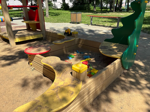 Empty sandpit in a playground with colorful toys