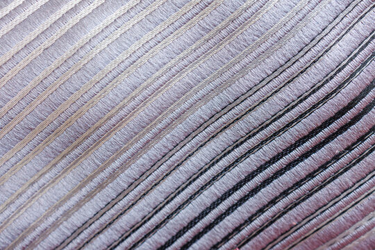 Decorative striped upholstery fabric with parallel stitched lines creating elegant textile texture
