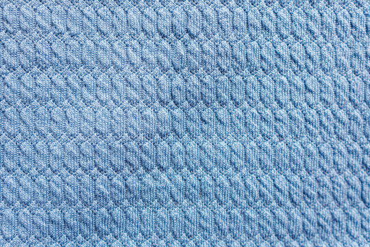 Light blue textured knit fabric with repeating raised geometric pattern seamless textile background