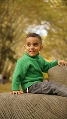 Smiling Little boy wearing green sweater outdoor © Ayman Alakhras