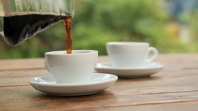 ガーデンテラスのテーブルでコーヒーを注ぐ