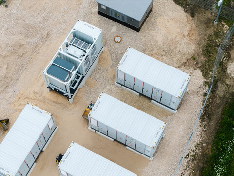 Aerial view of modular industrial containers and power equipment units arranged on a gravel site in Suntazi, Ogre Municipality, Latvia.